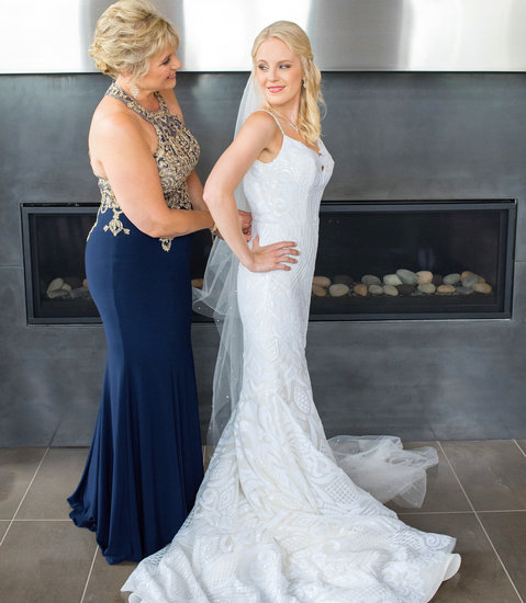 Bride's mom zips up her Blush West dress