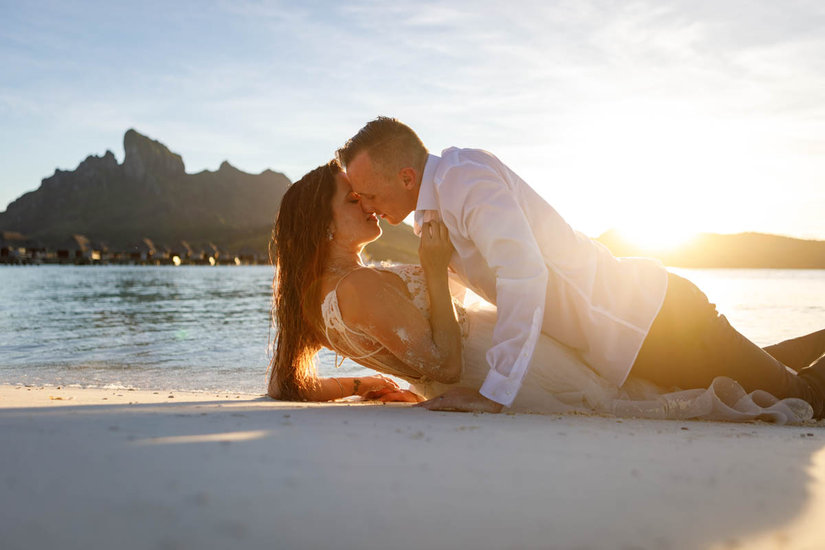 Bride and groom kissing in the beach