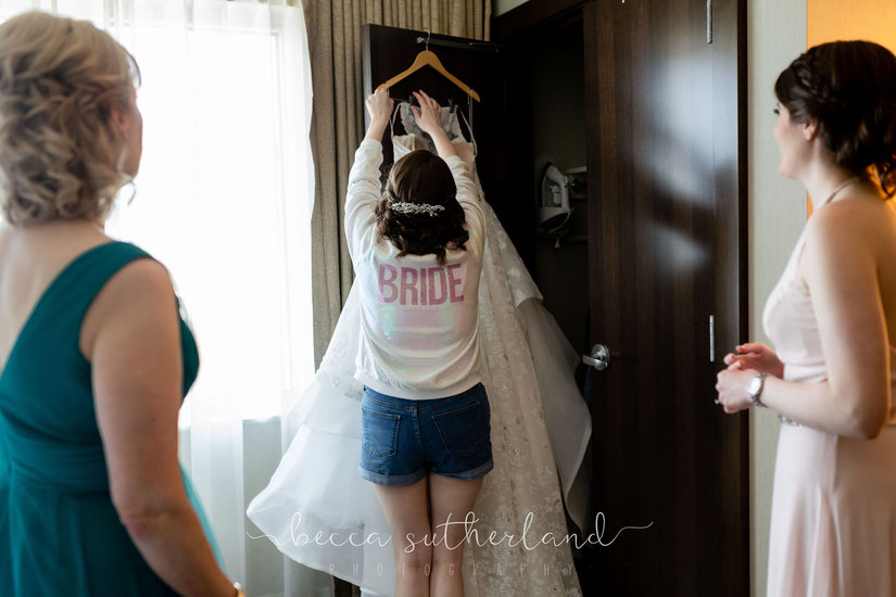 Bride takes dress off hanger