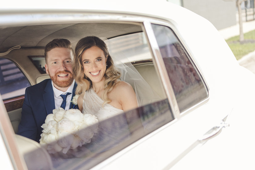 Bride and groom photo through window of Rolls Royce