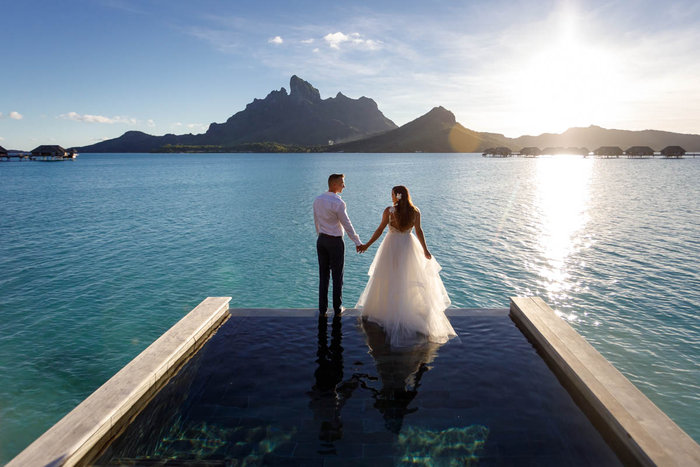 Bride and groom about to jump from their bungalow at the Four Seasons Resort Bora Bora
